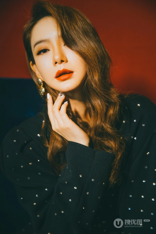 戚薇时尚柔美卷发发型，搭配黑衣波点裙，静坐沙发写真照