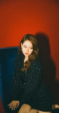 戚薇时尚柔美卷发发型，搭配黑衣波点裙，静坐沙发写真照