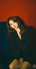 戚薇时尚柔美卷发发型，搭配黑衣波点裙，静坐沙发写真照