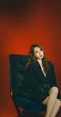 戚薇时尚柔美卷发发型，搭配黑衣波点裙，静坐沙发写真照