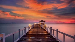 橙红彩霞海岸线，海上的礁石木栈道的唯美风景壁纸