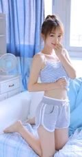 穿蓝色条纹肩带衣短裤的可爱漂亮丸子头少女室内写真照