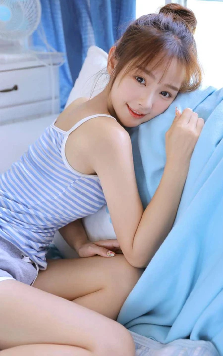 穿蓝色条纹肩带衣短裤的可爱漂亮丸子头少女室内写真照