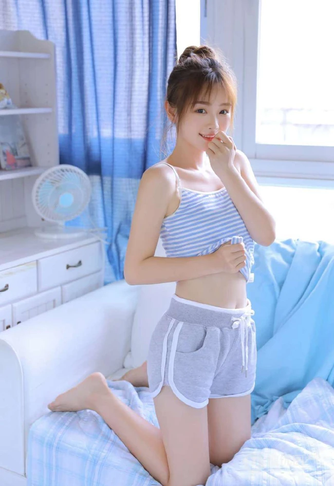 穿蓝色条纹肩带衣短裤的可爱漂亮丸子头少女室内写真照