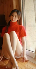 穿红色针织衫毛衣短裤的大眼睛单麻花辫美丽女孩艺术室内摄影图片
