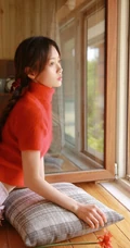 穿红色针织衫毛衣短裤的大眼睛单麻花辫美丽女孩艺术室内摄影图片
