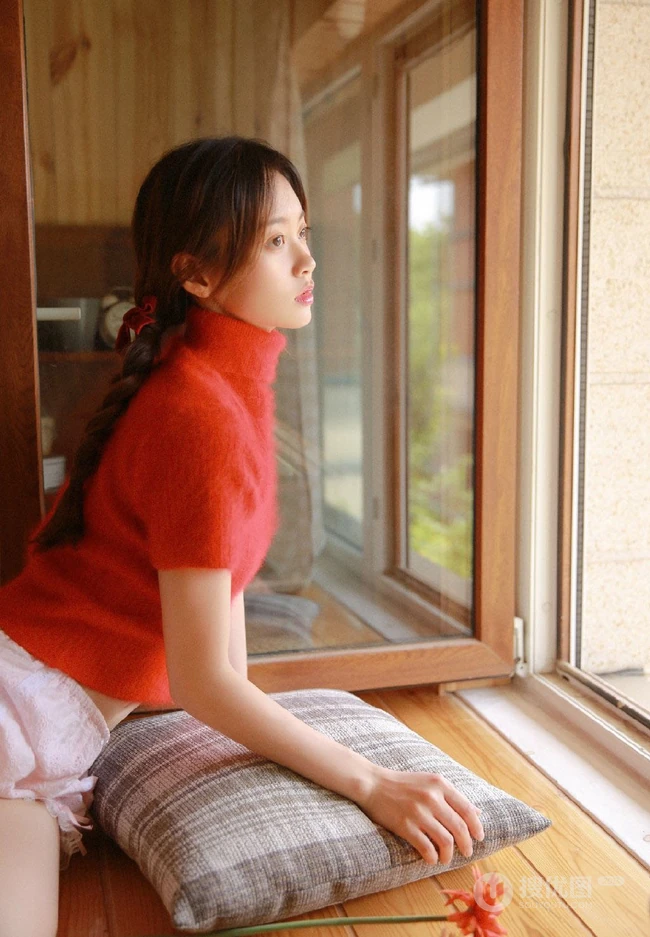 穿红色针织衫毛衣短裤的大眼睛单麻花辫美丽女孩艺术室内摄影图片