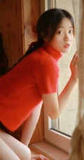 穿红色针织衫毛衣短裤的大眼睛单麻花辫美丽女孩艺术室内摄影图片