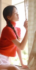 穿红色针织衫毛衣短裤的大眼睛单麻花辫美丽女孩艺术室内摄影图片