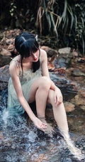 清澈见底的山间溪流中，一个穿着蓝色连衣裙的美丽麻花辫女孩摄影艺术照