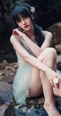 清澈见底的山间溪流中，一个穿着蓝色连衣裙的美丽麻花辫女孩摄影艺术照