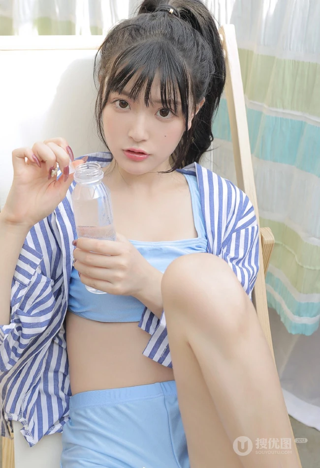 手拿花洒的气质漂亮少女身着蓝色肩带礼裙衣短裤显线条感蛮腰写真照