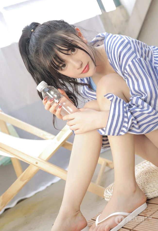 手拿花洒的气质漂亮少女身着蓝色肩带礼裙衣短裤显线条感蛮腰写真照