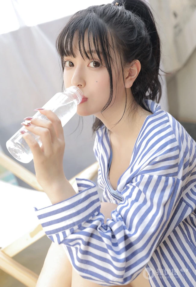 手拿花洒的气质漂亮少女身着蓝色肩带礼裙衣短裤显线条感蛮腰写真照
