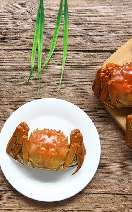 已蒸熟，摆放在盘里准备食用的大闸蟹图片