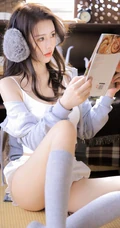 颜值高，身材好，戴着耳麦听音乐的漂亮小姐姐肩带背心短裤长筒袜室内照