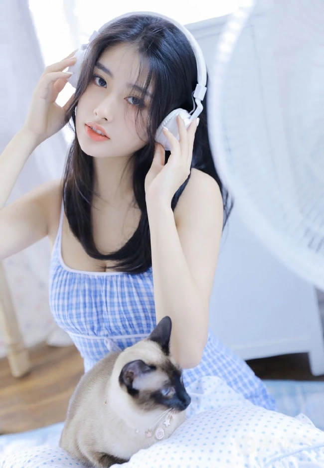 颜值高，身材好，戴着耳麦听音乐的漂亮小姐姐肩带背心短裤长筒袜室内照