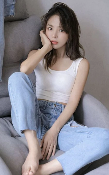 眼睛明亮的精致卷发女生小姐姐身着白色背心牛仔裤慵懒动人室内写真照