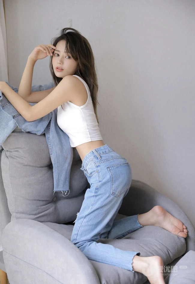 眼睛明亮的精致卷发女生小姐姐身着白色背心牛仔裤慵懒动人室内写真照