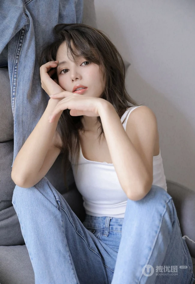 眼睛明亮的精致卷发女生小姐姐身着白色背心牛仔裤慵懒动人室内写真照