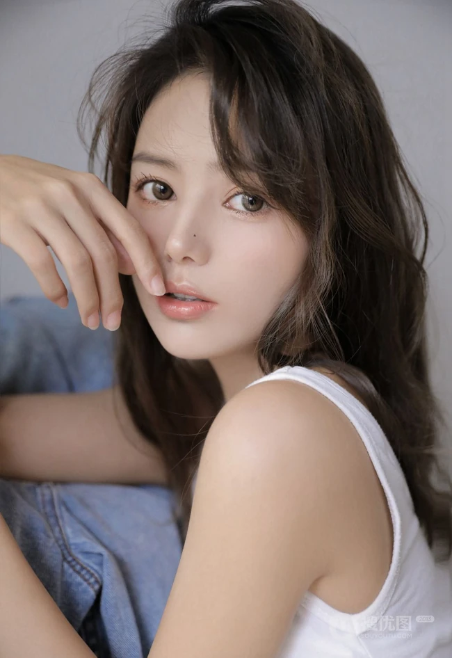 眼睛明亮的精致卷发女生小姐姐身着白色背心牛仔裤慵懒动人室内写真照