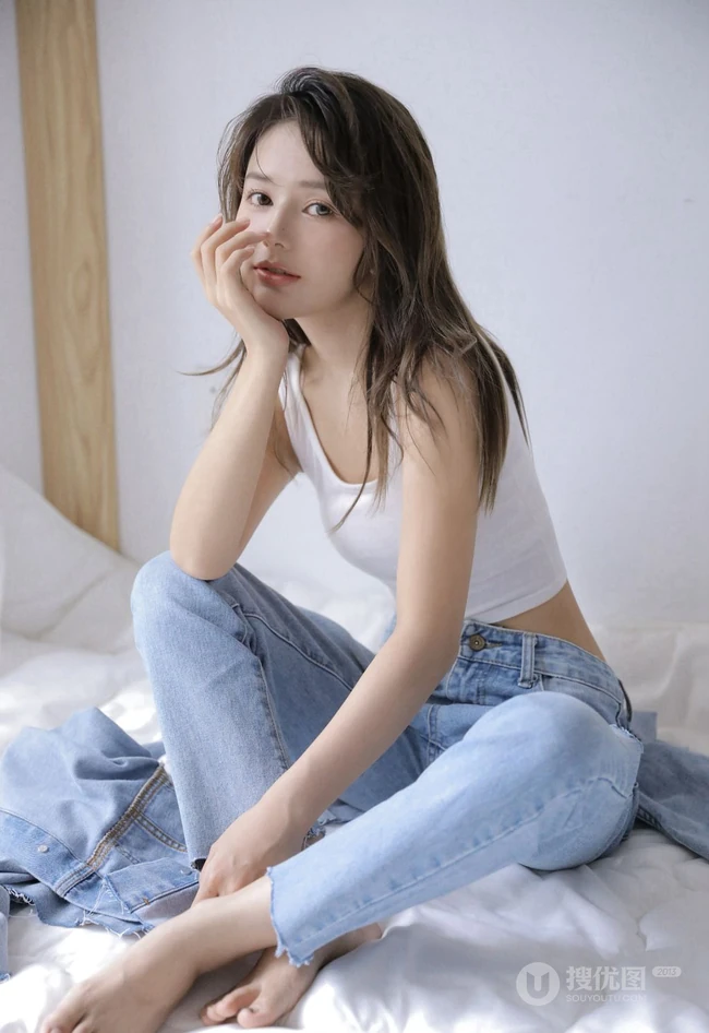 眼睛明亮的精致卷发女生小姐姐身着白色背心牛仔裤慵懒动人室内写真照