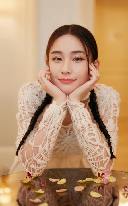 澳门赌王女儿何超莲双麻花辫发型可爱甜美镂空衣白裙写真照片