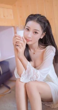 温柔甜美浅粉白皙女生气质低领白裙穿着喝牛奶吃早餐气质写真照片