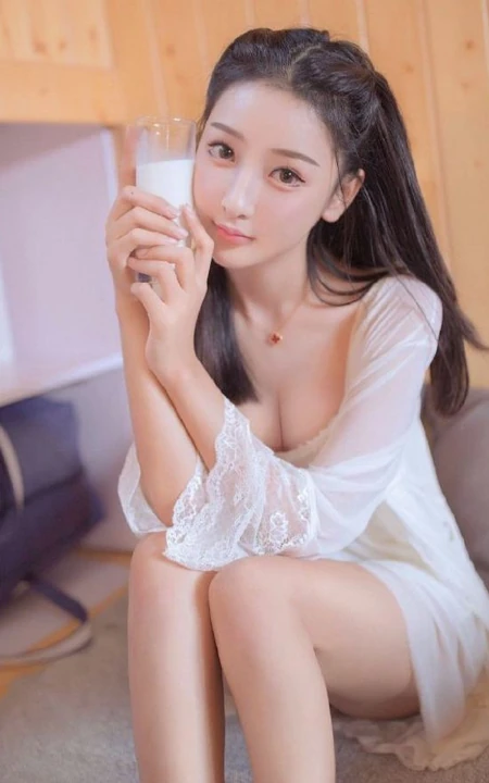 温柔甜美浅粉白皙女生气质低领白裙穿着喝牛奶吃早餐气质写真照片