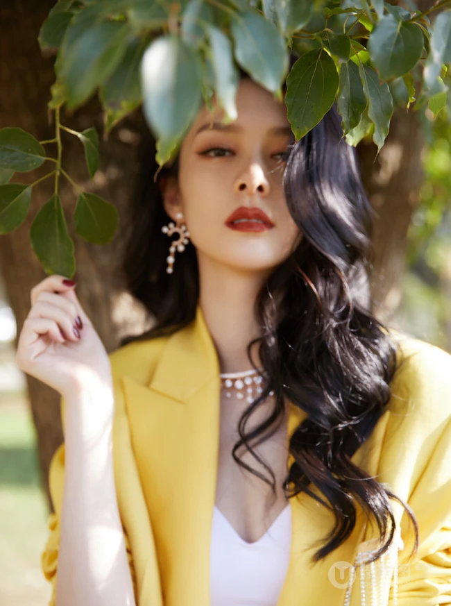 傅菁黄色西服套装搭配白色紧身背心酷美装扮，现身户外公园漫步写真美照
