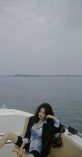王梓薇黑衣衬衫紧身裤海上游艇吹风写真图片