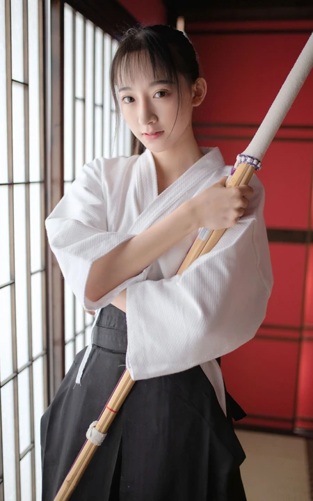 双手抱胸 拿着竹刀 身穿剑道服的双眼皮美女 高清4K手机壁纸图片