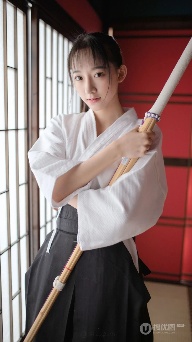 双手抱胸 拿着竹刀 身穿剑道服的双眼皮美女 高清4K手机壁纸图片