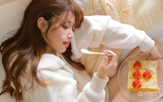 吃草莓蛋糕的软糯美萌少女暖色调毛衣短裤室内沙发高清气质写真图片