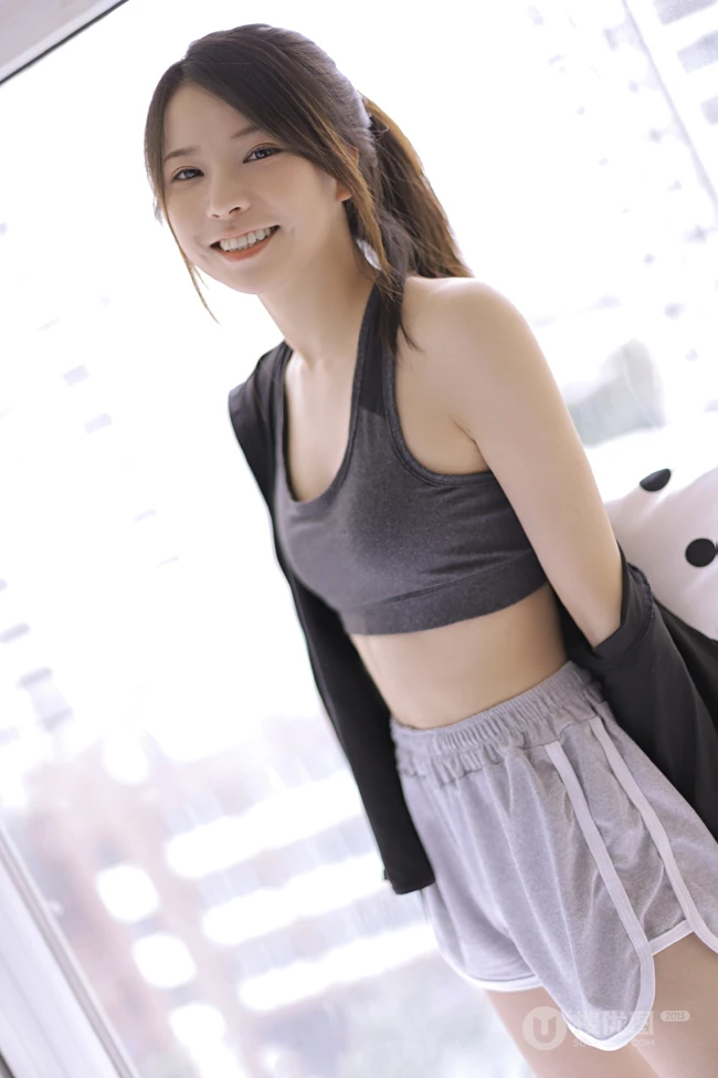 穿着运动肩带小背心短裤听音乐的马尾辫清新少女显蛮腰线条感室内图片