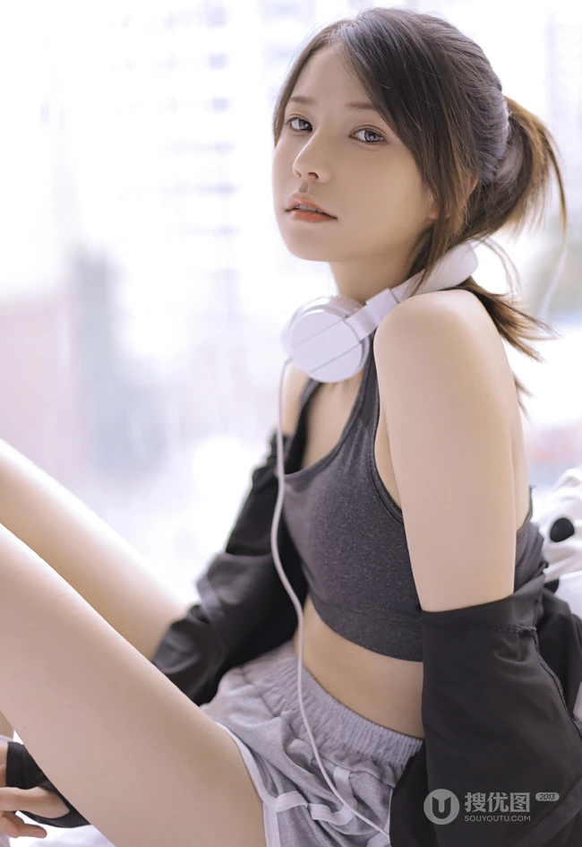 穿着运动肩带小背心短裤听音乐的马尾辫清新少女显蛮腰线条感室内图片