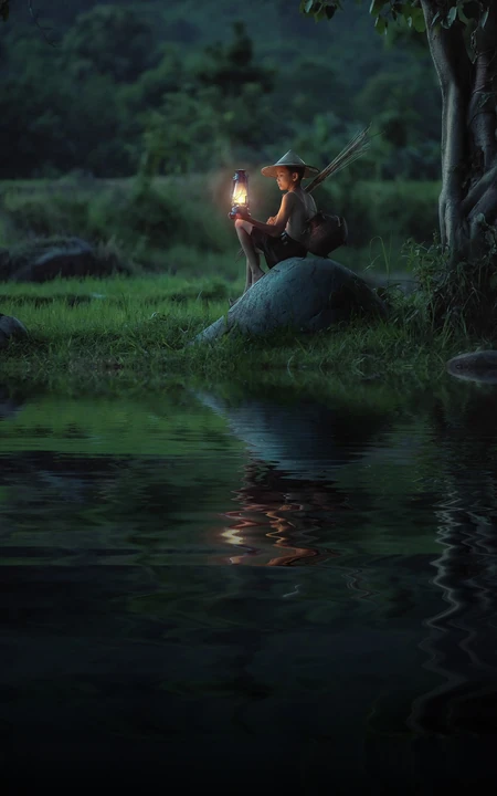 安静的夜，河边，一个提着灯笼的越南农村少年唯美手机壁纸图片