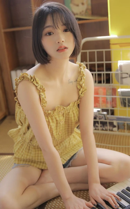 齐下巴短发娇小玲珑纹身少女黄色肩带衣牛仔短裤居家温暖室内照片