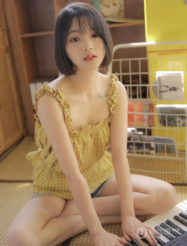 齐下巴短发娇小玲珑纹身少女黄色肩带衣牛仔短裤居家温暖室内照片