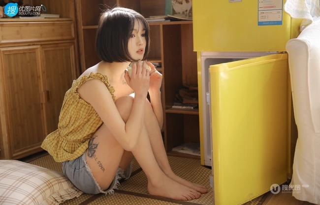 齐下巴短发娇小玲珑纹身少女黄色肩带衣牛仔短裤居家温暖室内照片