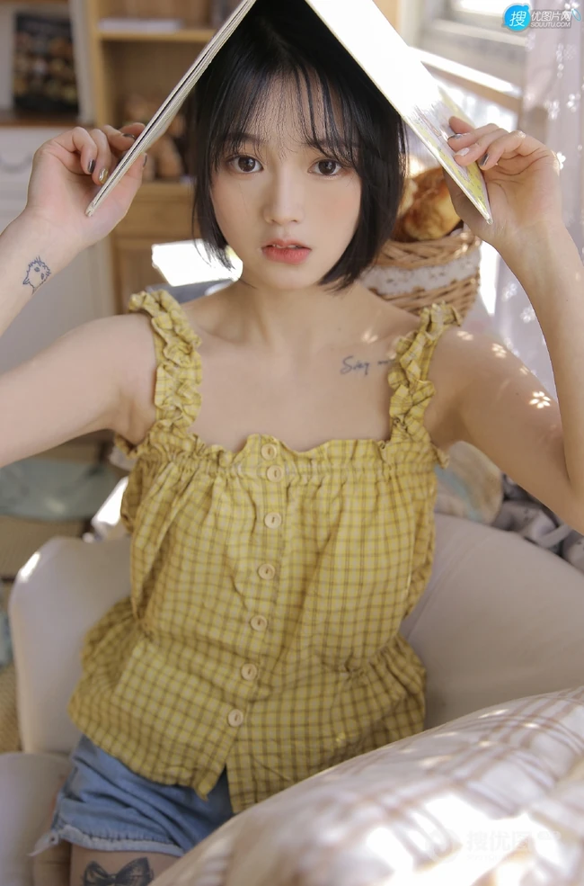齐下巴短发娇小玲珑纹身少女黄色肩带衣牛仔短裤居家温暖室内照片