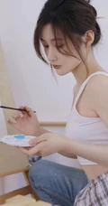 认真画画的样子好美，画室里穿着白色肩带文胸衣牛仔裤的女生写真图片