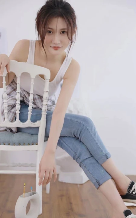 认真画画的样子好美，画室里穿着白色肩带文胸衣牛仔裤的女生写真图片