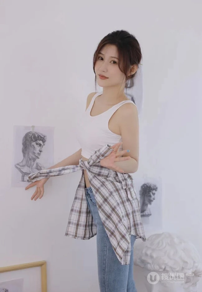 认真画画的样子好美，画室里穿着白色肩带文胸衣牛仔裤的女生写真图片