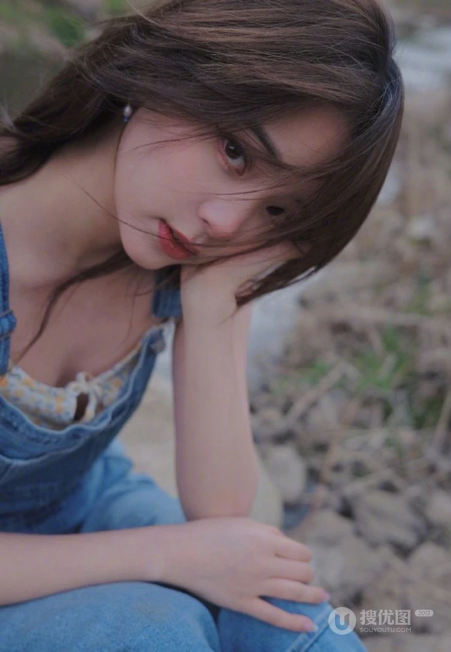 欧阳娜娜静坐河边石头上，单手托腮慵懒动人写真图片