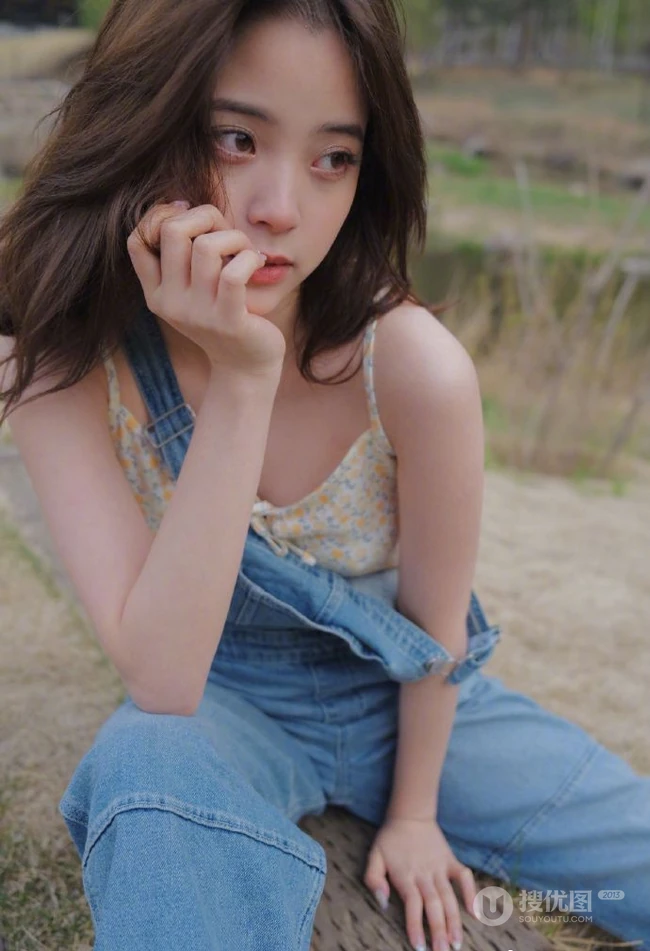 欧阳娜娜静坐河边石头上，单手托腮慵懒动人写真图片