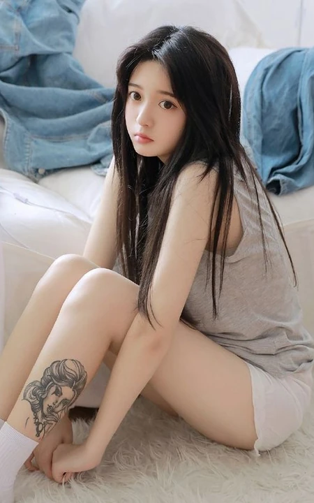 腿腕有纹身的大眼睛漂亮少女休闲T恤衫短裤居家沙发写真图片