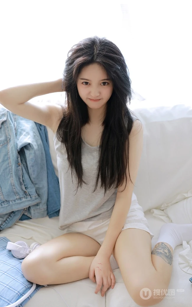 腿腕有纹身的大眼睛漂亮少女休闲T恤衫短裤居家沙发写真图片