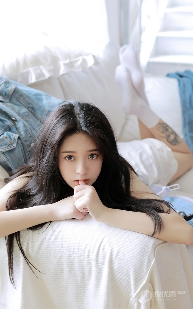 腿腕有纹身的大眼睛漂亮少女休闲T恤衫短裤居家沙发写真图片
