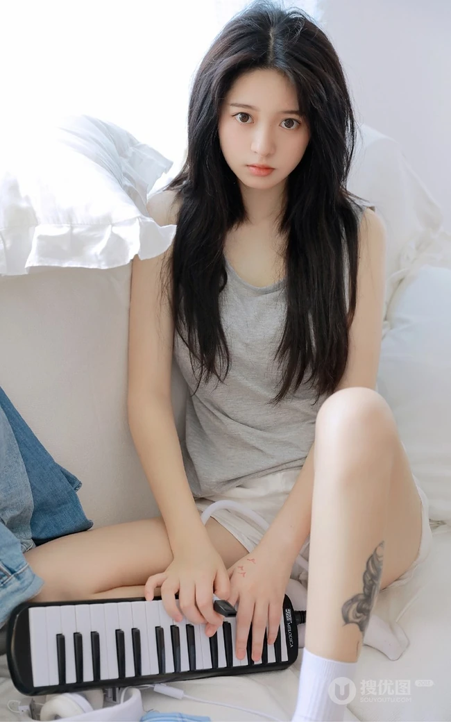 腿腕有纹身的大眼睛漂亮少女休闲T恤衫短裤居家沙发写真图片